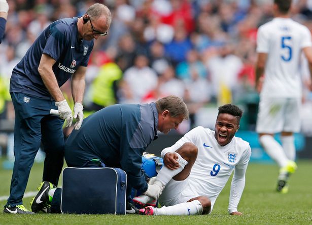 Gary Lewin England physiotherapists gives treatment to Raheem Sterling of England after an ankle injury